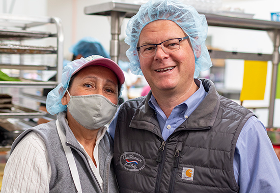 employee and bakery owner posing for picture.