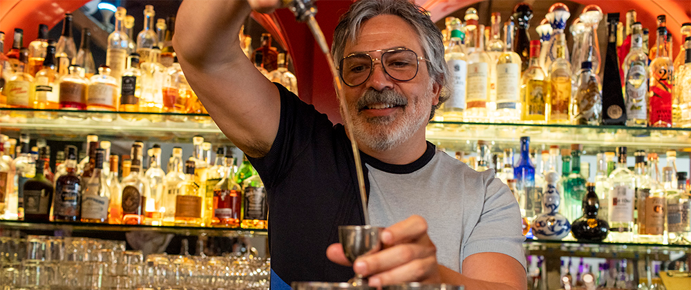 Business and bar owner mixing drinks at his bar.